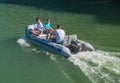 Grey pontoon with outboard engine with people at high speedSmall electric tourist boats for rent mooring Royalty Free Stock Photo