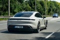 Grey Porsche Taycan 4S electric sedan driving quickly with motion blur effect