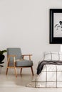 Grey retro armchair in white bedroom interior with wooden accents