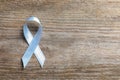 Grey ribbon on wooden background, top view