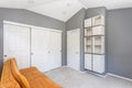 Grey room interior with bright orange sofa.