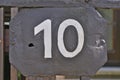 A grey house number plaque, showing the number ten