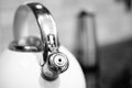 Grey-scale shot of a kettle on the stove in a kitchen