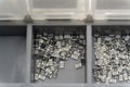 Grey scattered microscopic SMT surface mount chip resistors sorted in grey storage container