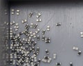 Grey scattered microscopic SMT surface mount chip resistors sorted in grey storage container