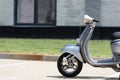 Grey scooter on road near blurred