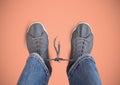 Grey shoes on feet with pink background