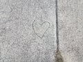 Grey sidewalk or pavement with heart carved into it Royalty Free Stock Photo