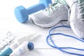 Grey sneakers, blue dumbbell, medication on a white background Royalty Free Stock Photo