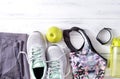 Grey sneakers, grey leggings, pink top, sportswear , green Apple, water bottle, sports bracelet on a white wooden  top view Royalty Free Stock Photo