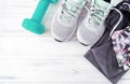 Grey sneakers, leggings, turquoise dumbbell, top, sportswear on a white wooden Royalty Free Stock Photo