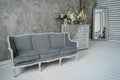 Grey sofa with chest of drawers against a gray wall