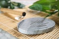 Grey stone coaster with acupuncture needles on bamboo mat Royalty Free Stock Photo