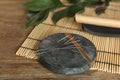 Grey stone coaster with acupuncture needles on wooden table Royalty Free Stock Photo