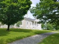 Grey stone house with green grass and trees Royalty Free Stock Photo