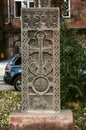 Grey cross-stone with an arch over the cross, a carved figure of a Saint on a horse and a circle-a symbol of eternity on the Alley