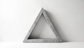 Grey stone triangle frame on white background with shadow. Minimalist stone triangular structure on white surface. Simple Royalty Free Stock Photo