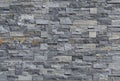 Grey stone wall cladding made of strips and square blocks stacked . Background and texture. Royalty Free Stock Photo