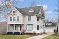 A grey suburban home with a red front door.