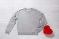 Grey sweatshirt mockup. Valentines Day concept shirt, giftbox heart shape on wooden background. Copy space, template blank front Royalty Free Stock Photo