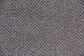 Grey textile background. Knitting with grey yarn. The texture of the knitted fabric
