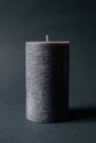 grey textured candle on black background