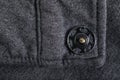 Grey type of cloth that shows the stitching and button for background