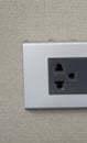 Grey universal electricity sockets plug on a yellow wall. Royalty Free Stock Photo