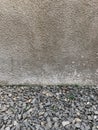 The grey wall of rought cement with rocks