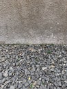 The grey wall of rought cement with rocks