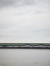 Wooden pier bridge across water on grey cloudy day