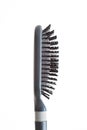 Grey well-used hair brush with handle and visible signs of wear dandruff and skin shavings close up shot isolated on white