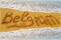 Grey, wet, sea wave washed up on the beach in the summer morning. Inscription beach country Belgium on the coast of Europe