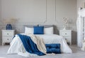 Grey, white and blue pillows and blanket on king size bed in elegant bedroom with copy space Royalty Free Stock Photo