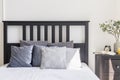 Grey and white pillows on bed with black headboard in simple bed Royalty Free Stock Photo