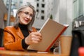 Grey white senior woman reading book while sitting in cafe Royalty Free Stock Photo