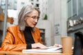 Grey white senior woman reading book while sitting in cafe Royalty Free Stock Photo