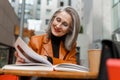 Grey white senior woman reading book while sitting in cafe Royalty Free Stock Photo