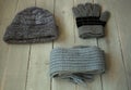 Grey winter hat gloves scarf on a wooden bacground