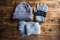 Grey winter hat gloves scarf on a wooden bacground