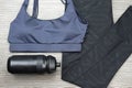 Grey women`s sports bra and Black Bicycle water bottle. Sport fashion and accessories.