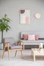 Grey wooden armchair next to table in living room interior with Royalty Free Stock Photo