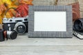 Grey wooden background with classic camera, empty photo frame, l Royalty Free Stock Photo