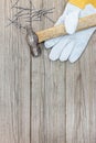 Grey wooden background with old hammer, nails and working gloves Royalty Free Stock Photo