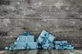 Grey wooden christmas background with a stack of presents in blu