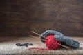 Grey wool mitten with red tweed yarn ball and knitting needles Royalty Free Stock Photo