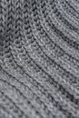 Grey woolen knitted scarf. Closeup view texture with bokeh. Royalty Free Stock Photo