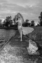 Greyscale of a blonde model standing near a lake surrounded by greenery in Buffalo in the US Royalty Free Stock Photo