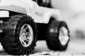 Greyscale closeup shot of the wheels of a toy car on the carpet Royalty Free Stock Photo