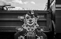 Greyscale of a clown poster attached to an ld truck with duct tape